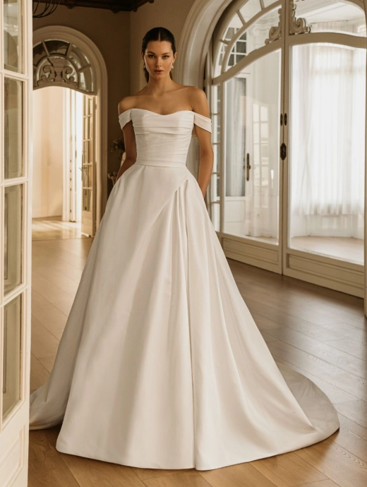 ÉLYSÉE Bridal HALIMA luxury Mikado ball gown wedding dress featuring an off-the-shoulder sweetheart neckline, softly draped bodice, elegant pleated skirt and sweeping cathedral train.