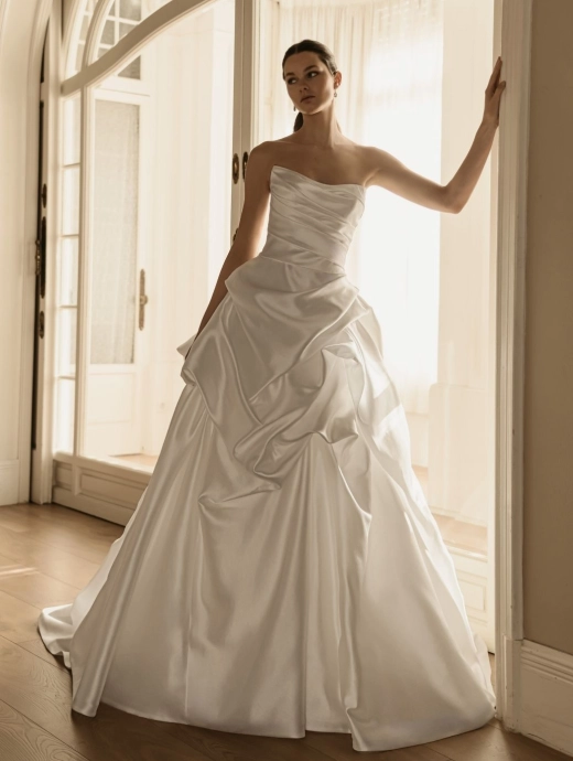 ÉLYSÉE Bridal HAYDEE luxury satin ball gown wedding dress featuring a sculpted strapless sweetheart neckline, draped bodice, architectural ruffle overskirt and sweeping cathedral train.